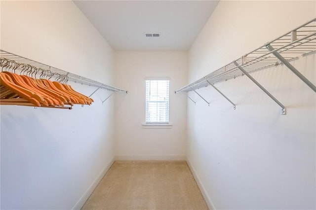 spacious closet with visible vents and light colored carpet