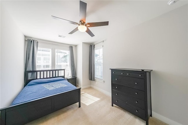 bedroom featuring baseboards, ceiling fan, visible vents, and light colored carpet