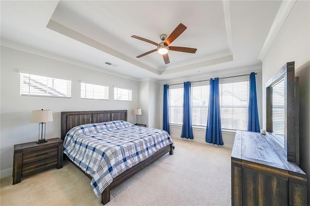 bedroom with crown molding, a raised ceiling, visible vents, a ceiling fan, and light carpet