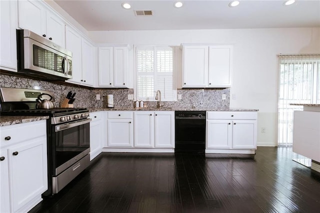 kitchen with stone counters, white cabinetry, and appliances with stainless steel finishes