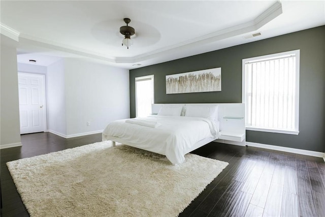 unfurnished bedroom featuring ceiling fan, dark hardwood / wood-style flooring, a raised ceiling, and crown molding