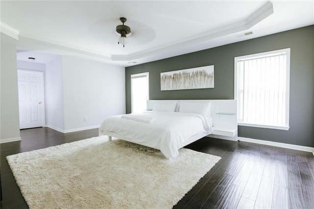 unfurnished bedroom with a raised ceiling, ceiling fan, dark hardwood / wood-style flooring, and ornamental molding