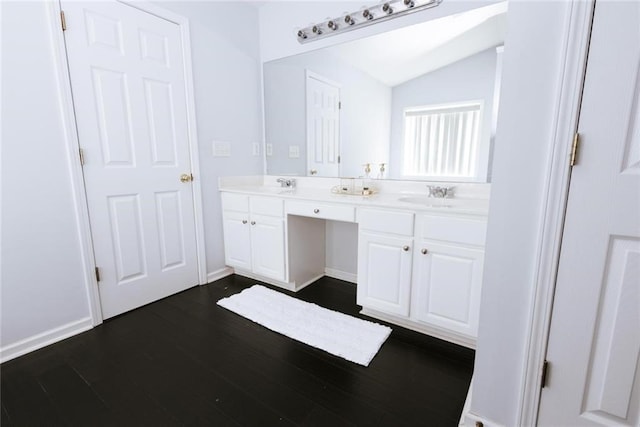 bathroom featuring vanity, wood-type flooring, and lofted ceiling