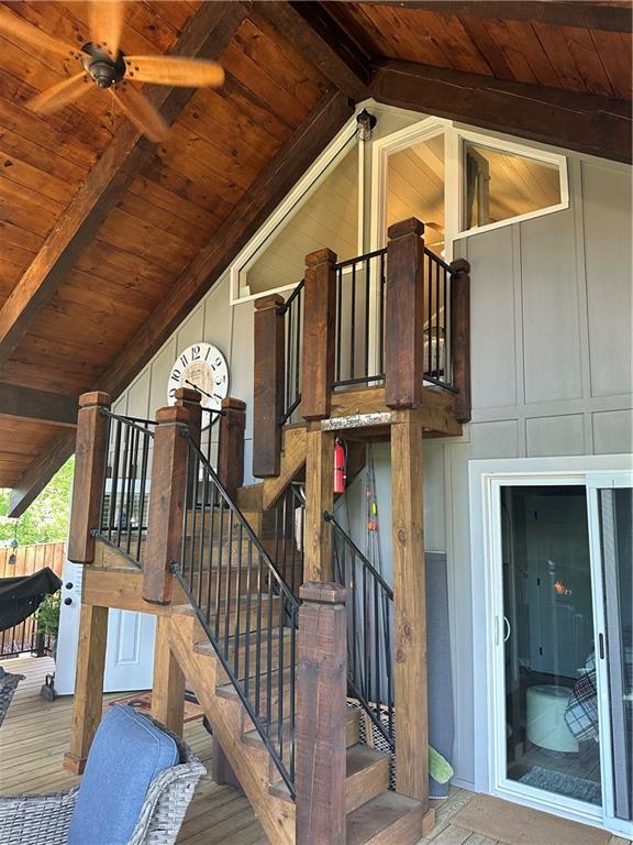 staircase featuring ceiling fan, high vaulted ceiling, wooden ceiling, and beamed ceiling