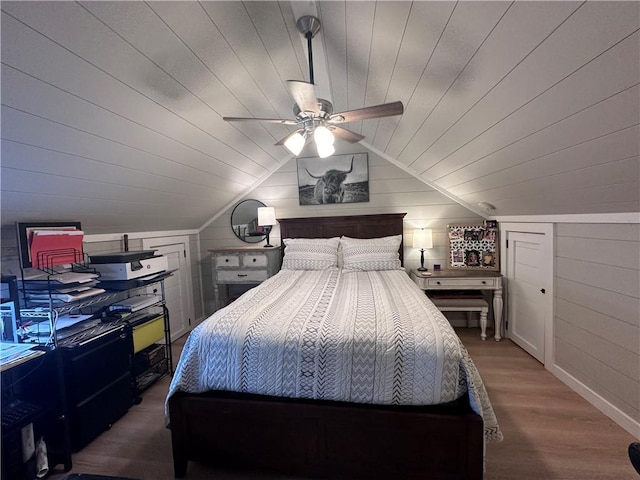 bedroom with lofted ceiling, ceiling fan, hardwood / wood-style floors, wooden walls, and wooden ceiling