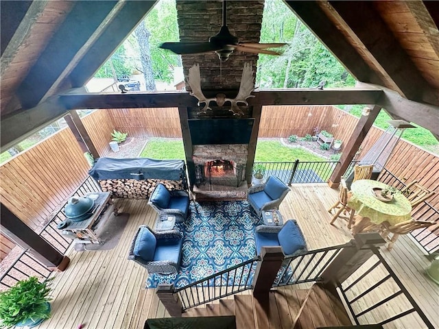 wooden terrace featuring ceiling fan and an outdoor living space with a fireplace