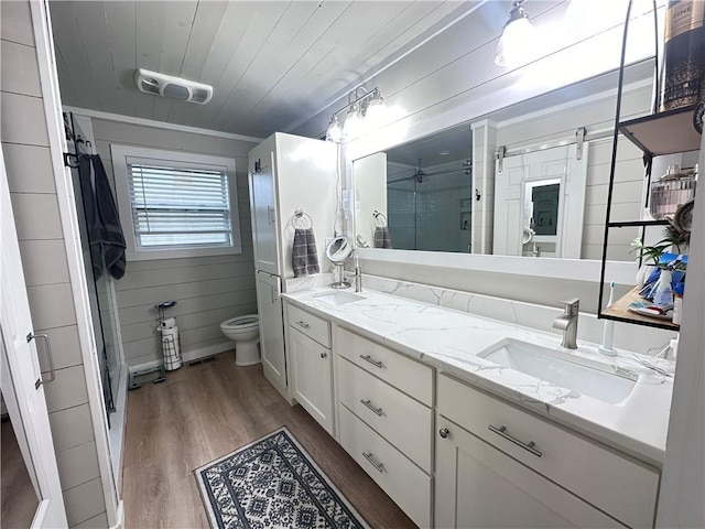 bathroom with toilet, wood-type flooring, wooden ceiling, vanity, and wooden walls