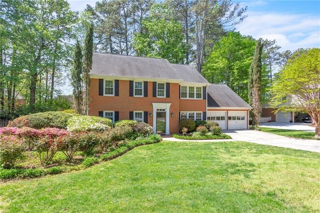colonial-style house with an attached garage, driveway, and a front yard