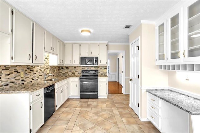 kitchen with black appliances, light stone counters, backsplash, light tile patterned floors, and white cabinets
