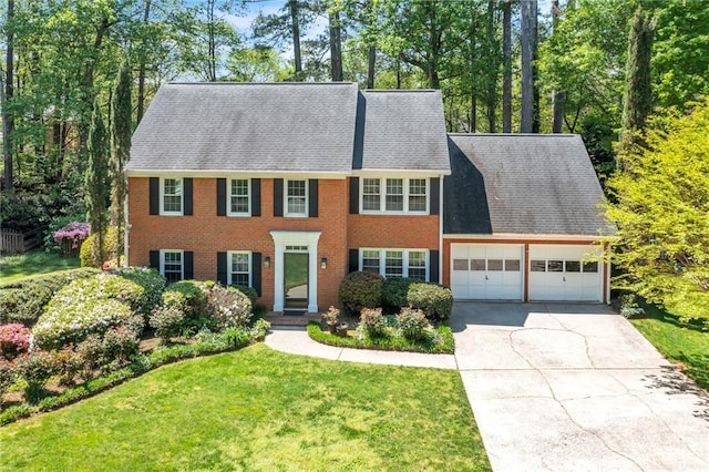 colonial-style house with a garage, driveway, a front lawn, and brick siding