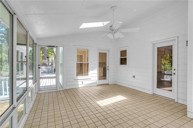 unfurnished sunroom with lofted ceiling, a ceiling fan, and a skylight