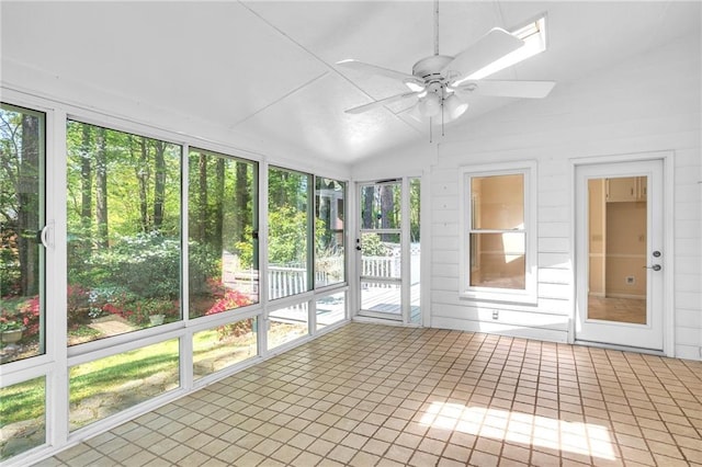 unfurnished sunroom with a ceiling fan, lofted ceiling, and tile patterned floors
