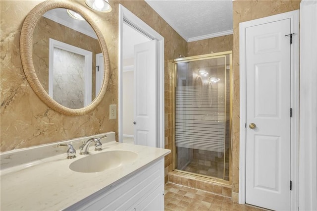 bathroom featuring a shower stall, vanity, crown molding, and a textured ceiling