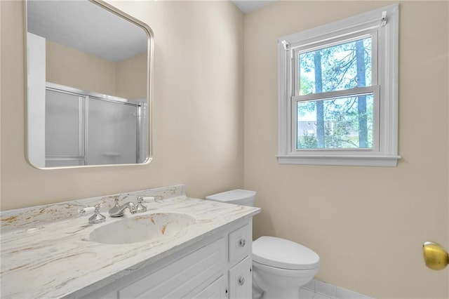 bathroom with a shower with shower door, vanity, toilet, and tile patterned flooring