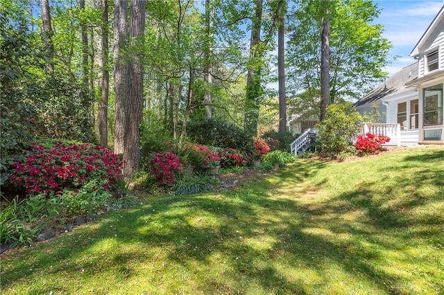 view of green lawn with a wooden deck