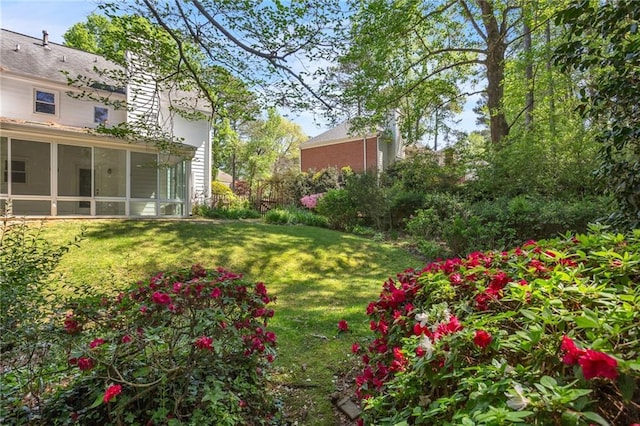 view of grassy yard featuring a sunroom