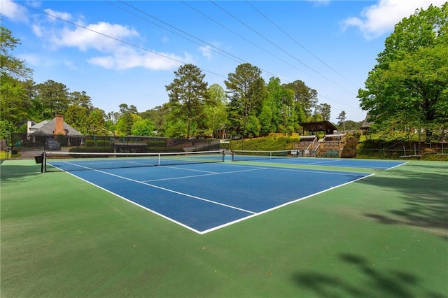 view of tennis court featuring view of scattered trees