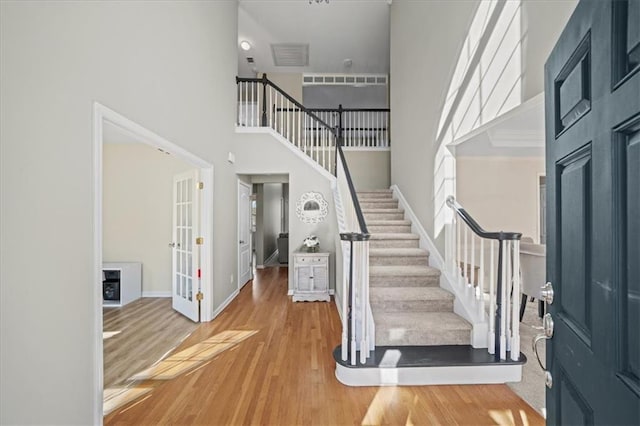 foyer entrance featuring hardwood / wood-style flooring and a high ceiling