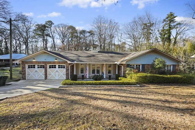 ranch-style house featuring a garage, a front yard, and covered porch