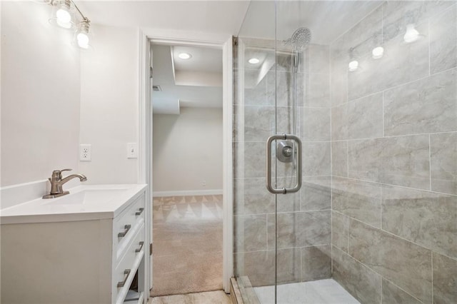 bathroom featuring vanity, baseboards, a stall shower, and recessed lighting