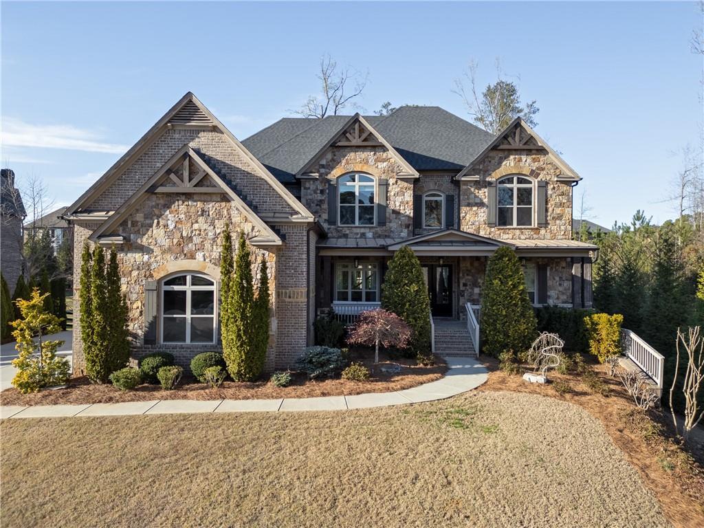 12640 Hearthstone Way, Alpharetta, GA 30009 - view of front of home with stone siding, a porch, and a front yard
