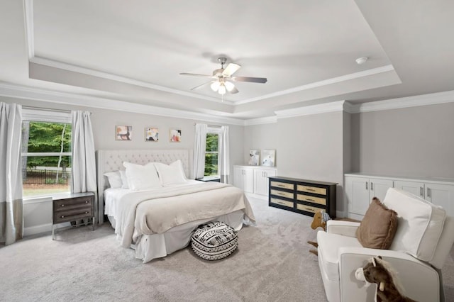 bedroom with ceiling fan, crown molding, a tray ceiling, and carpet