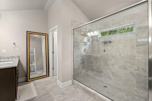 bathroom featuring tile patterned flooring, vaulted ceiling, a shower with door, and vanity