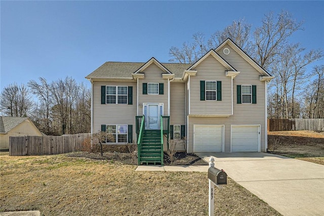 view of front of home with an attached garage, fence, concrete driveway, and a front yard