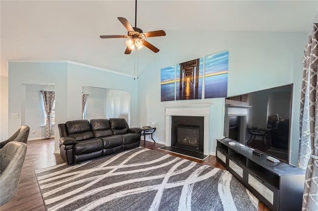 living room featuring high vaulted ceiling, a fireplace with flush hearth, a ceiling fan, baseboards, and dark wood-style floors