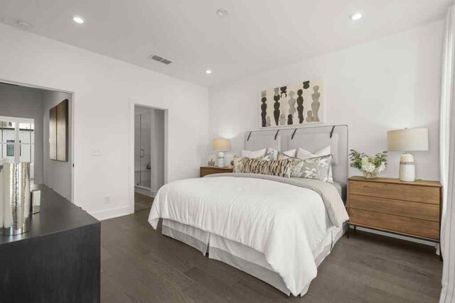 bedroom featuring dark hardwood / wood-style flooring and ensuite bath