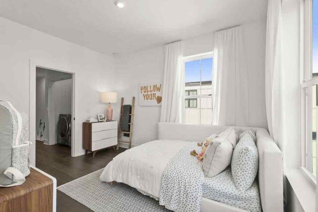 bedroom with dark wood-type flooring, multiple windows, and washer / dryer