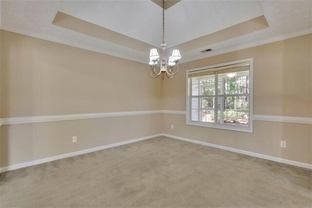 carpeted spare room featuring a notable chandelier, crown molding, and a raised ceiling