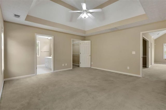 unfurnished bedroom with a raised ceiling and light carpet