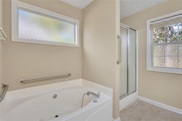 bathroom featuring plus walk in shower and tile patterned flooring