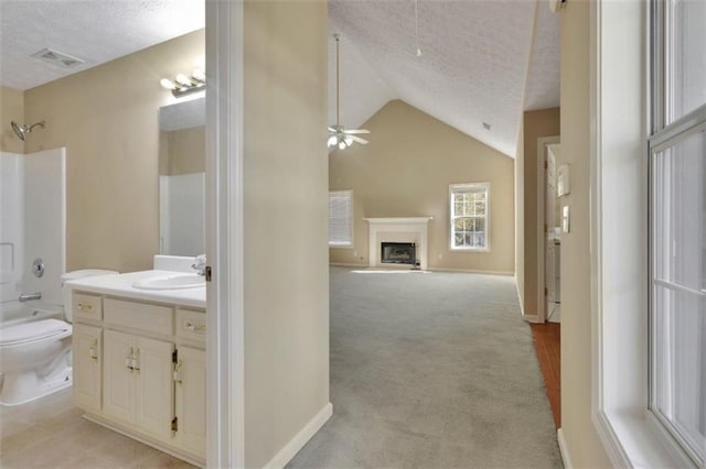 full bathroom with toilet, bathtub / shower combination, a textured ceiling, vaulted ceiling, and vanity