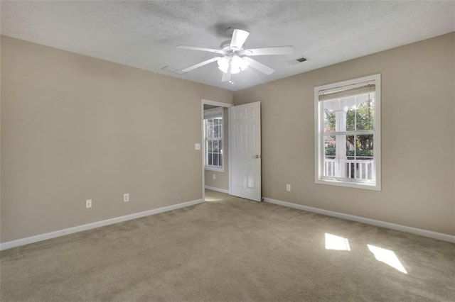 carpeted empty room with a textured ceiling and ceiling fan