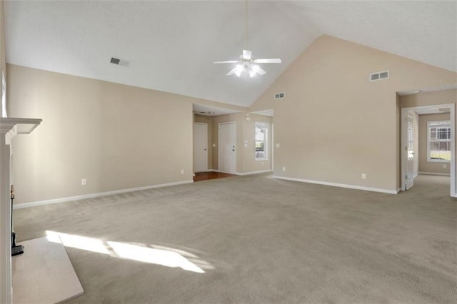 unfurnished living room with high vaulted ceiling, ceiling fan, and light colored carpet