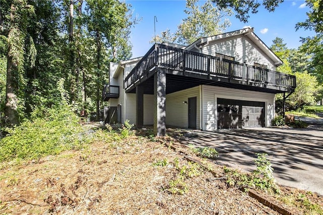 view of property exterior featuring a wooden deck and driveway