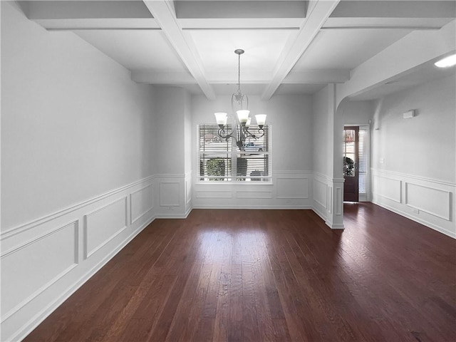 unfurnished dining area with a notable chandelier, arched walkways, beamed ceiling, and wood finished floors