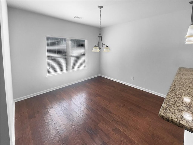 unfurnished dining area with dark wood-type flooring, visible vents, and baseboards