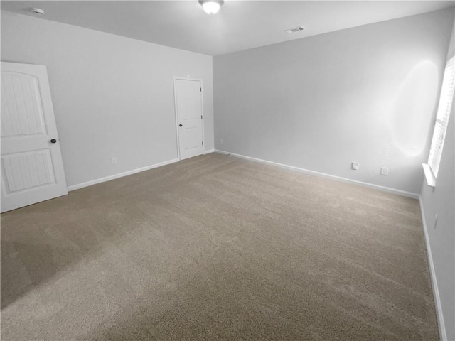 carpeted spare room with baseboards and visible vents