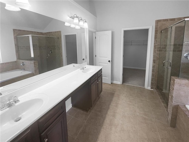 bathroom featuring a garden tub, a shower stall, a spacious closet, and a sink