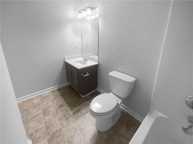 bathroom with baseboards, vanity, and toilet