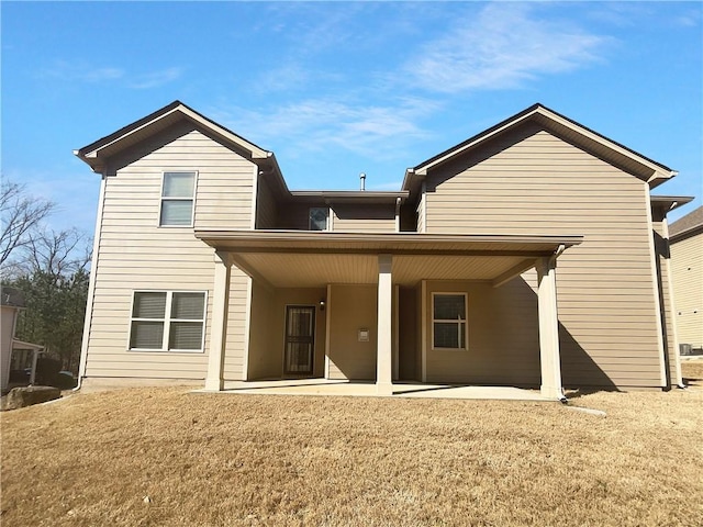 rear view of house featuring a patio and a yard