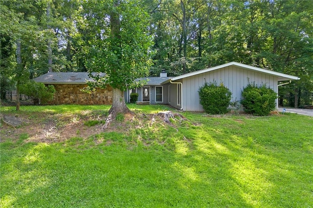 1328 Hidden Hills Pkwy, Stone Mountain, GA 30088 - view of front of house with a chimney, a front lawn, and board and batten siding