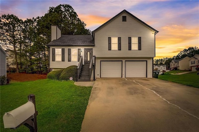 split level home with a garage and a lawn