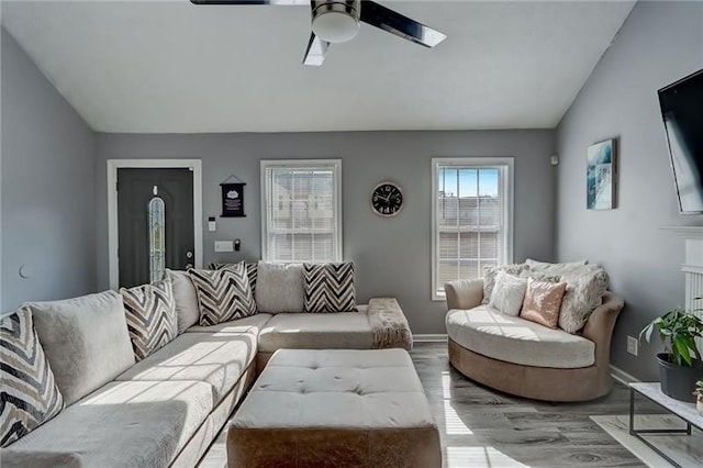 living room with vaulted ceiling, ceiling fan, and light wood-type flooring