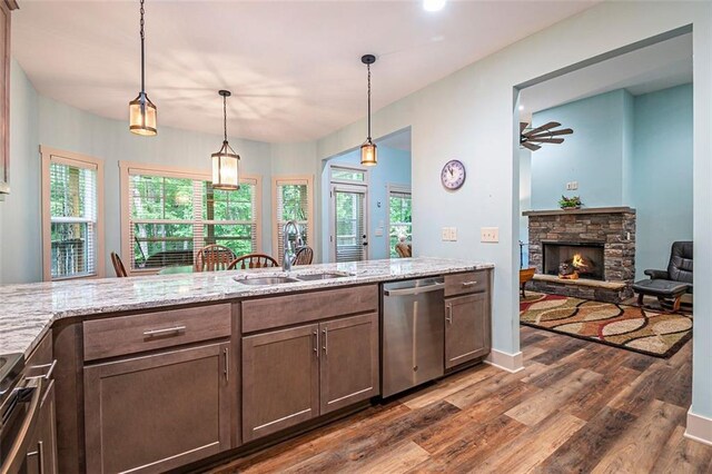 562 Yonah Lake Dr, Sautee Nacoochee, GA 30572 - kitchen featuring stainless steel appliances, a sink, dark wood finished floors, a fireplace, and light stone countertops