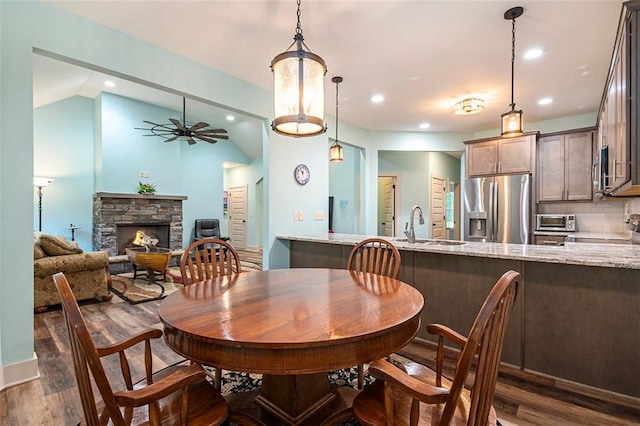 562 Yonah Lake Dr, Sautee Nacoochee, GA 30572 - dining room with dark wood finished floors, a stone fireplace, a ceiling fan, lofted ceiling, and recessed lighting