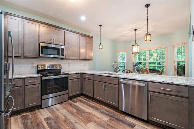 562 Yonah Lake Dr, Sautee Nacoochee, GA 30572 - kitchen with stainless steel appliances, a sink, dark wood-style flooring, tasteful backsplash, and light stone countertops